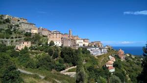 a town on top of a hill near the ocean at Studio vue mer in Cervione