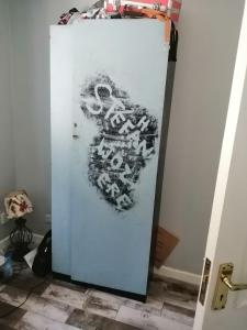 a white refrigerator with graffiti on the side of it at The bungalow in Waterford Manor Station