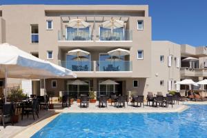 a hotel with a swimming pool and tables and chairs at Jechrina in Kato Daratso
