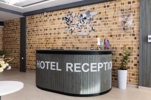 a hotel reception desk in front of a brick wall at Air Solief in Tashkent