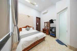 a bedroom with a bed and a flat screen tv at TRUNG LÀI HOTEll in Ấp Thái Thương