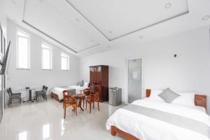 a bedroom with two beds and a table and chairs at TRUNG LÀI HOTEll in Ấp Thái Thương