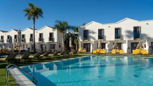 a swimming pool in front of some white buildings at FBC Fortuny Resort - Adults Only in Maspalomas