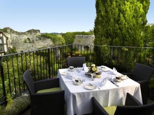 a table with a white table cloth on a balcony with a castle at Amberley Castle- A Relais & Chateaux Hotel in Amberley