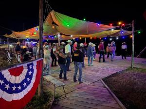 a crowd of people walking under a tent at night at Ranch du Haut-Languedoc in La Salvetat