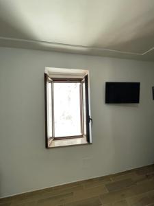 een kamer met een raam en een tv aan de muur bij Dimora AVE in Aieta