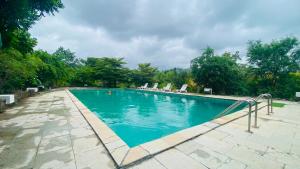 a large swimming pool with chairs and trees at The Yellow Retreat in Wai