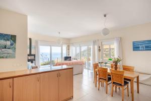 a kitchen and living room with a table and chairs at Michalis Holiday Home in Ravdhoúkha