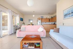 a living room with a pink bed and a couch at Michalis Holiday Home in Ravdhoúkha