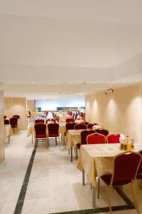 a dining room with tables and red chairs and tablesearcher at فندق نخبة الجوار in Al Khansāk +19 photos
