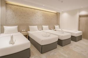 a room with three beds and a wall at فندق نخبة الجوار in Al Khansāk