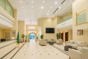 a lobby with couches and chairs and a television at فندق نخبة الجوار in Al Khansāk