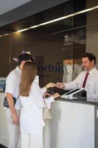 a woman and two men standing at a counter at FBC Fortuny Resort - Adults Only in Maspalomas +125 photos