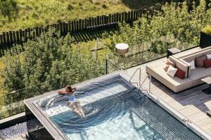a woman is in a swimming pool in a house at Hotel Fameli in Valdaora