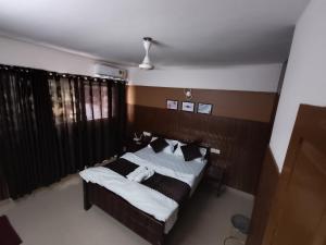 a bedroom with a bed with white sheets and pillows at Hovato Brown in Nedumbassery