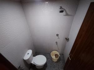 a small bathroom with a toilet and a trash can at Hovato Brown in Nedumbassery