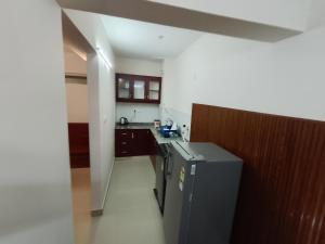 a kitchen with a sink and a refrigerator in it at Hovato Brown in Nedumbassery