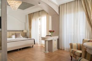 a bedroom with a bed and a table with flowers on it at Grand Hotel Gallia in Milano Marittima +78 photos