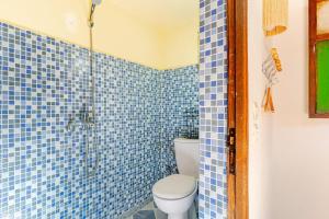 a blue tiled bathroom with a toilet and a shower at Gîte Imsker Elbour in Asni