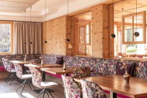 a restaurant with wooden walls and tables and chairs at Hotel Fameli in Valdaora