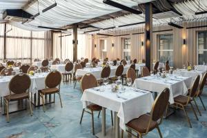 a restaurant with white tables and chairs and windows at Kosher Hotel King David Prague in Prague