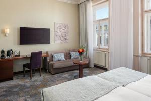 a hotel room with a bed and a desk at Kosher Hotel King David Prague in Prague