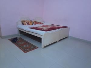 a bed in a room with a rug next to it at Hare Krishna hotel in Orchha