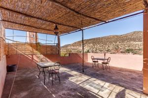 a patio with a table and chairs and a view at Gîte Imsker Elbour in Asni
