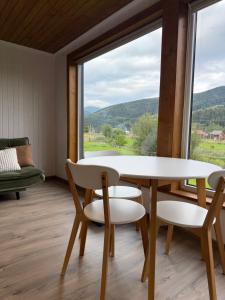 a table and chairs in a room with a large window at Pletey house in Verkhovyna