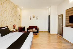 a hotel room with a bed and a chair at HoTEL KAMAL VINTAGE in Kāthgodām