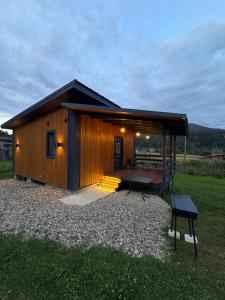 a small wooden cabin with a porch and a deck at Pletey house in Verkhovyna