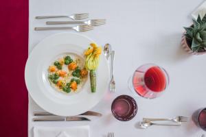 a white table with a bowl of food and silverware at Hotel Fameli in Valdaora +85 photos