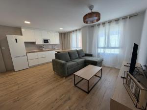 a living room with a couch and a table and a kitchen at AMANITA VuT in Huerta del Rey