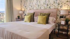 a bedroom with a large white bed with yellow pillows at Marbella Views in Ojén