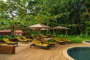 a deck with chairs and umbrellas next to a pool at Belo Monte - Principe Collection in Santo António