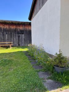 a row of plants next to a building with a bench at Linden House in Sklené