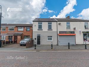 a street view of a building with a garage at Modern Serviced Apartments in St Helens with Free WiFi Ideal for Leisure or Work Stays by North West Accommodation in Saint Helens