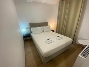 a bedroom with a white bed with two towels on it at Raianos in Tui