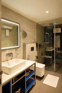 a bathroom with a sink and a tub and a toilet at Zone by The Park Darjeeling in Darjeeling