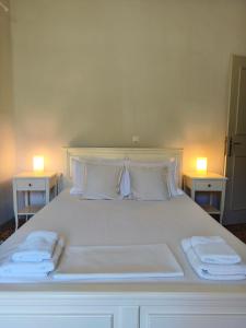 a large white bed with two nightstands and two lamps at Parga Heritage in Parga