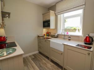 a small kitchen with a sink and a window at Waterside Lodge in Lockerbie