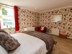a bedroom with two beds and floral wallpaper at Waterside Lodge in Lockerbie
