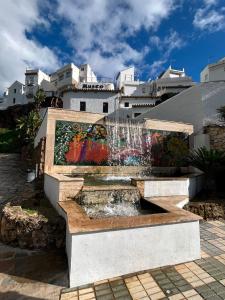 a fountain in front of a building with a mural at Marbella Views in Ojén