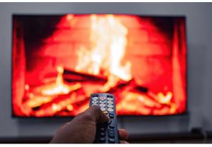 a person holding a remote control in front of a fireplace at Lunora Homes in Arusha