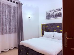 a bedroom with a white bed and a window at Lunora Homes in Arusha