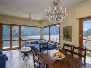 a living room with a dining table and a chandelier at Apartment Miralago by Interhome in Oria