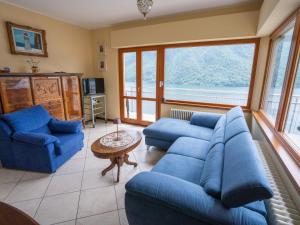 a living room with blue couches and a table at Apartment Miralago by Interhome in Oria +54 photos