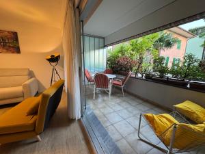 a balcony with a couch and a table and chairs at Ikigai Ascona in Ascona +1 photo