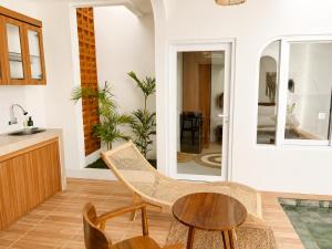 a living room with a table and chairs and a kitchen at Ayodhya Villa Patran in Kejayan +21 photos
