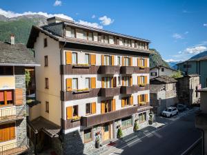 an apartment building with balconies on a city street at Hotel Funivia in Chiesa in Valmalenco